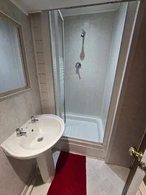 a bathroom with a sink and a shower at Wilsons Lodge in Blackpool