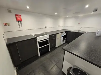 a kitchen with a stove and a washer and dryer at Wilsons Lodge in Blackpool