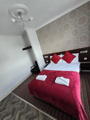 a bedroom with a large bed with red pillows at Wilsons Lodge in Blackpool