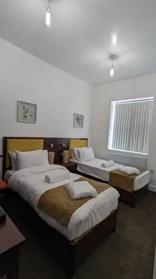 a room with two beds and a window at Hotel Blackpool in Blackpool
