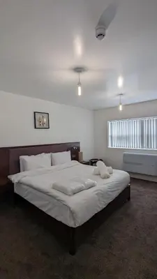 a bedroom with a large bed with white sheets at Hotel Blackpool in Blackpool