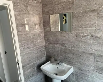 a bathroom with a sink and a mirror at Stylish Home - Close to City Centre, Anfield Stadium - Free Parking in Litherland
