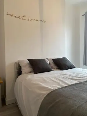 a bed in a bedroom with the words just insane written on the wall at Stylish Home - Close to City Centre, Anfield Stadium - Free Parking in Litherland
