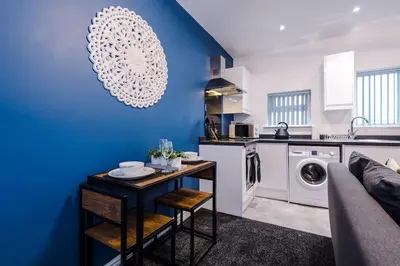a kitchen and living room with a blue wall at Rocky Lane Urban Apartments by Charming Apartments - Flat 5 in Liverpool