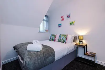 a bedroom with a white bed with a white towel on it at Rocky Lane Urban Apartments by Charming Apartments - Flat 5 in Liverpool