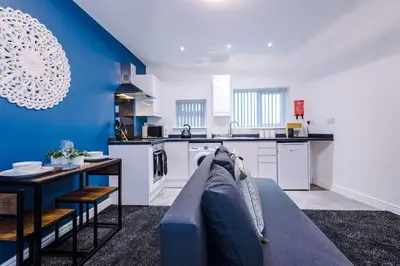 a living room with a couch and a kitchen at Rocky Lane Urban Apartments by Charming Apartments - Flat 5 in Liverpool