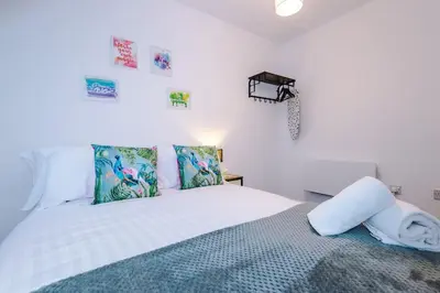 a bedroom with a bed with white sheets and pillows at Rocky Lane Urban Apartments by Charming Apartments - Flat 5 in Liverpool