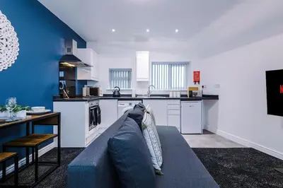 a living room with a couch and a kitchen at Rocky Lane Urban Apartments by Charming Apartments - Flat 5 in Liverpool
