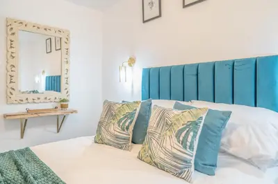a bedroom with a bed with a blue headboard and pillows at Beautifully Designed 1 Bed Flat in Morecambe