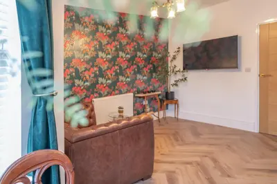a living room with a couch and a floral wall at Beautifully Designed 1 Bed Flat in Morecambe