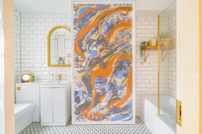 a bathroom with a painting on the shower door at Beautifully Designed 1 Bed Flat in Morecambe