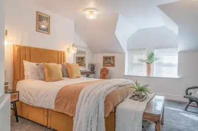 a bedroom with a large bed and a desk at Gorgeous New 1 Bedroom Penthouse Flat in Morecambe