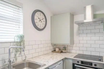 a kitchen with a sink and a clock on the wall at Gorgeous New 1 Bedroom Penthouse Flat in Morecambe