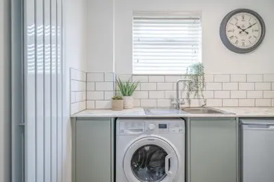 a kitchen with a washing machine and a sink at Gorgeous New 1 Bedroom Penthouse Flat in Morecambe