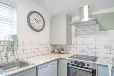 a kitchen with a clock on the wall above a sink at Gorgeous New 1 Bedroom Penthouse Flat in Morecambe