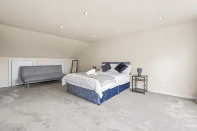 a bedroom with a bed and a bench in it at LUXURIOUS HOLIDAY HOME Bolton in Bolton