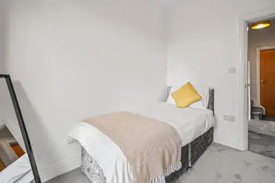 a bedroom with a bed with a yellow pillow on it at LUXURIOUS HOLIDAY HOME Bolton in Bolton