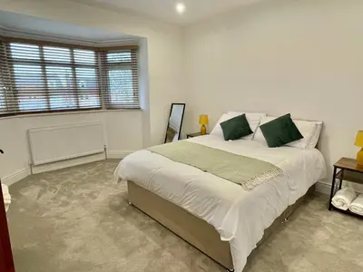 a bedroom with a large bed and a window at LUXURIOUS HOLIDAY HOME Bolton in Bolton