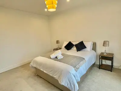 a bedroom with a large bed with two night stands at LUXURIOUS HOLIDAY HOME Bolton in Bolton