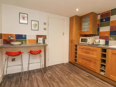 a kitchen with two stools and a counter top at Stork Cottage in Lancaster