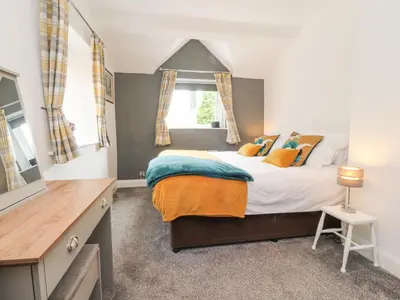 a bedroom with a large bed and a window at Stork Cottage in Lancaster
