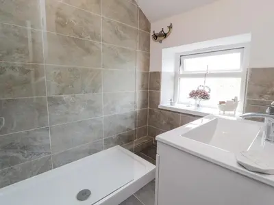 a bathroom with a sink and a bath tub at Stork Cottage in Lancaster