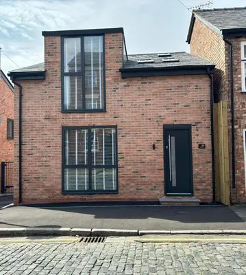 a brick house with a black door on a street at Pilgrim House by Phoenix Collection in Liverpool