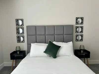 a bedroom with a large white bed with a green pillow at Pilgrim House by Phoenix Collection in Liverpool
