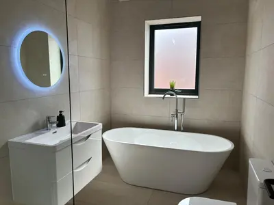 a bathroom with a tub and a sink and a mirror at Pilgrim House by Phoenix Collection in Liverpool