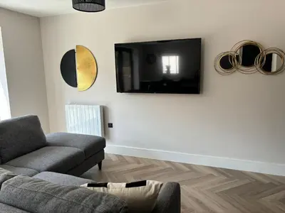 a living room with a couch and a tv on the wall at Pilgrim House by Phoenix Collection in Liverpool