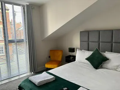 a bedroom with a bed and a chair and a window at Pilgrim House by Phoenix Collection in Liverpool
