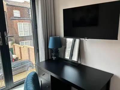 a black desk with a television on a wall with a window at Pilgrim House by Phoenix Collection in Liverpool