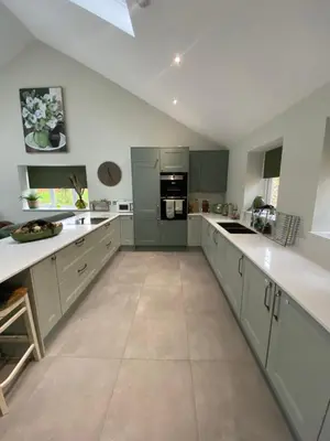 a large kitchen with green cabinets and white counter tops at Luxurious and Peaceful Lakeside House, Clitheroe in Clitheroe