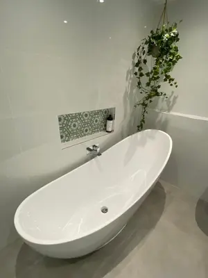 a white bath tub in a bathroom with a plant at Luxurious and Peaceful Lakeside House, Clitheroe in Clitheroe