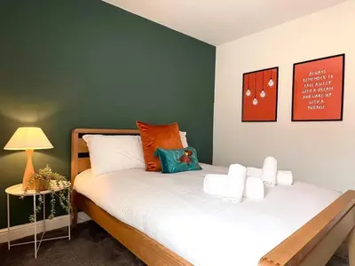 a bedroom with two beds and a green wall at Quaint 2Bed House near Wigan Centre in Ince-in-Makerfield