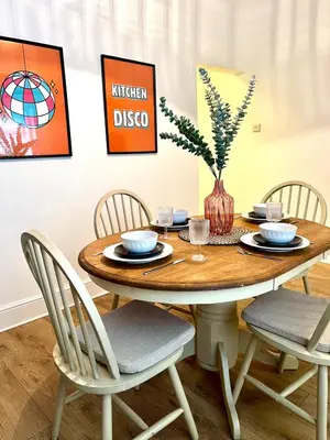 a dining room table with chairs and a vase on it at Quaint 2Bed House near Wigan Centre in Ince-in-Makerfield