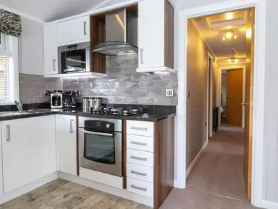 a kitchen with white cabinets and a stove at Capenwray in Carnforth