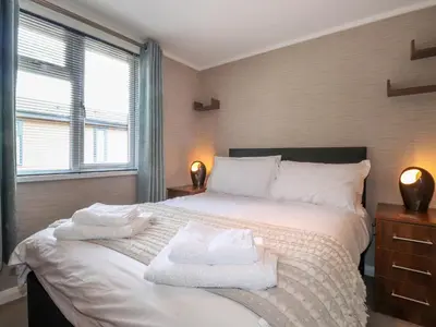 a bedroom with a large bed with towels on it at Capenwray in Carnforth