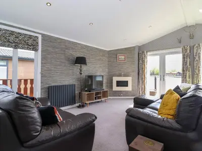 a living room with two leather couches and a television at Capenwray in Carnforth