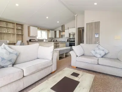 a living room with two couches and a kitchen at Coniston in Carnforth