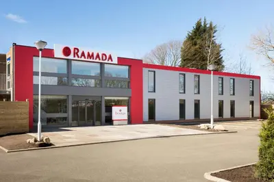 a red and white building with a sign on it at Ramada Chorley South in Chorley