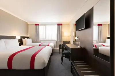 a hotel room with two beds and a desk with a desk at Ramada Chorley South in Chorley