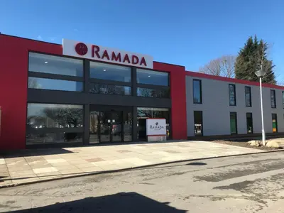 a red and white building with a sign on it at Ramada Chorley South in Chorley
