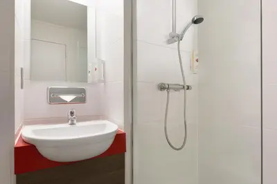 a white bathroom with a sink and a shower at Ramada Chorley South in Chorley