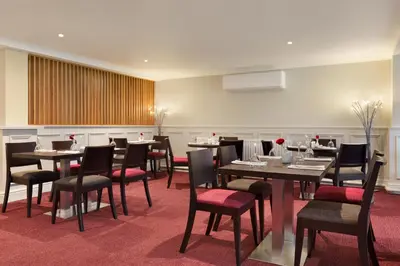 a restaurant with tables and chairs in a room at Ramada Chorley South in Chorley