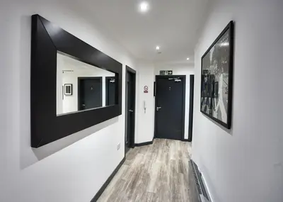 a hallway with black and white paintings on the walls at MCCARTNEY SUITE 5 Bedrooms, 5 bathrooms in Liverpool