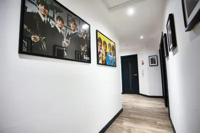 a hallway with pictures on the walls of a room at MCCARTNEY SUITE 5 Bedrooms, 5 bathrooms in Liverpool