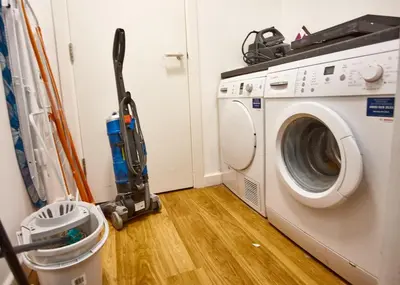 a vacuum cleaner next to a washing machine at MCCARTNEY SUITE 5 Bedrooms, 5 bathrooms in Liverpool