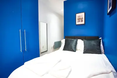 a bedroom with blue walls and a white bed at STARR SUITE 6 Bedrooms, 6 Bathrooms in Liverpool