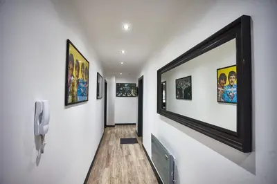 a hallway with paintings on the walls of a house at STARR SUITE 6 Bedrooms, 6 Bathrooms in Liverpool